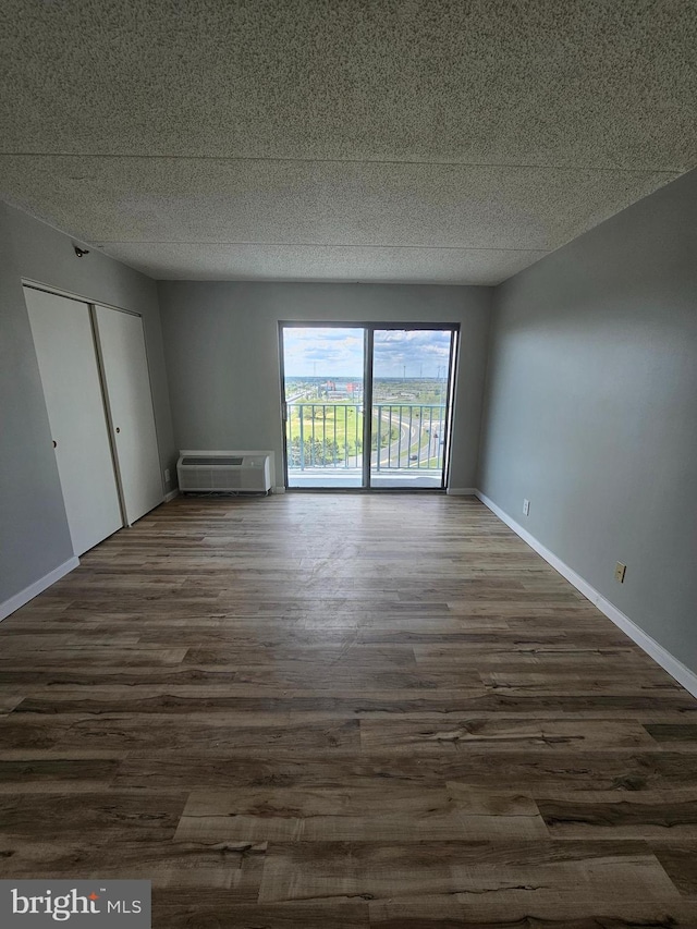 655 Absecon Blvd Unit 1002, Atlantic City, NJ 08401 - empty room featuring dark wood-type flooring, a textured ceiling, and an AC wall unit