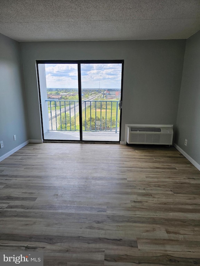 655 Absecon Blvd Unit 1002, Atlantic City, NJ 08401 - unfurnished room featuring a wall unit AC, wood finished floors, and a textured ceiling