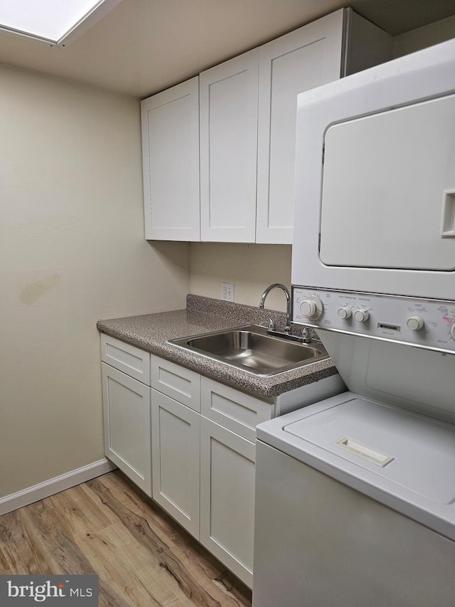 655 Absecon Blvd Unit 1002, Atlantic City, NJ 08401 - washroom with estacked washer and dryer, cabinet space, and light wood-style flooring