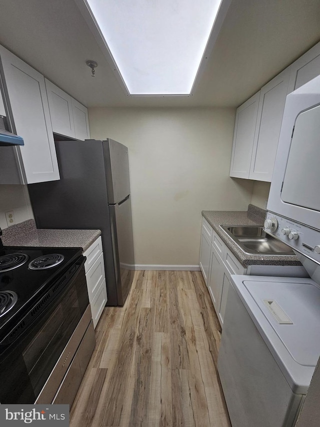655 Absecon Blvd Unit 1002, Atlantic City, NJ 08401 - kitchen with electric stove, stacked washing machine and dryer, white cabinetry, light wood-style floors, and exhaust hood