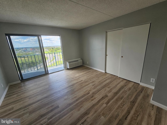655 Absecon Blvd Unit 1002, Atlantic City, NJ 08401 - unfurnished bedroom with wood finished floors, access to exterior, a wall mounted air conditioner, a closet, and a textured ceiling