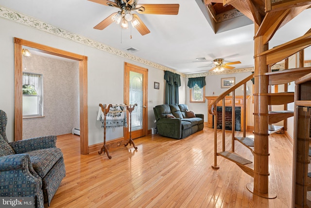 942 Paul St, Gloucester City, NJ 08030 - living area featuring ceiling fan, stairs, light wood-type flooring, wallpapered walls, and a baseboard radiator