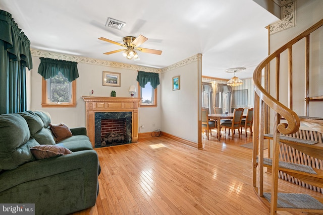 942 Paul St, Gloucester City, NJ 08030 - living room featuring ceiling fan, light wood-style flooring, a high end fireplace, a chandelier, and stairs