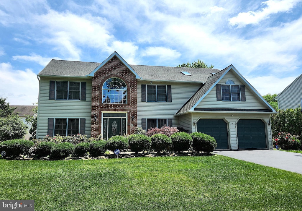 45 Downing Dr, Wyomissing, PA 19610 - view of front of house with concrete driveway, an attached garage, and a front lawn