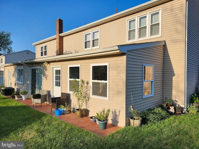 32 Devonshire Dr, Reading, PA 19610 - rear view of property featuring a yard, a patio area, and a chimney