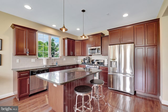 3017 Bainbridge Dr, Lansdale, PA 19446 - kitchen with stainless steel appliances, light wood-type flooring, dark stone counters, a kitchen bar, and a kitchen island