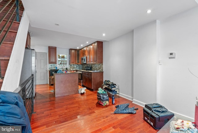 1847 Gerritt St, Philadelphia, PA 19146 - kitchen with a center island, backsplash, wood finished floors, stainless steel appliances, and recessed lighting