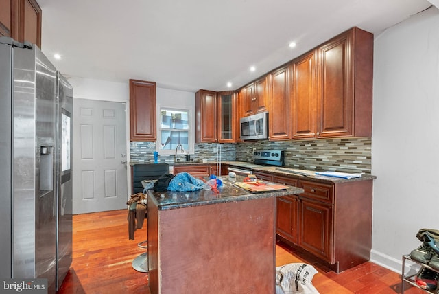 1847 Gerritt St, Philadelphia, PA 19146 - kitchen with appliances with stainless steel finishes, light wood finished floors, backsplash, recessed lighting, and dark stone counters