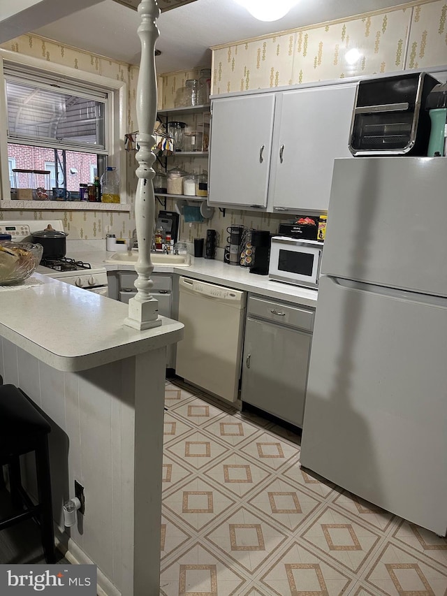 3432 Hartel Ave, Philadelphia, PA 19136 - kitchen with white appliances, light countertops, white cabinetry, and a peninsula