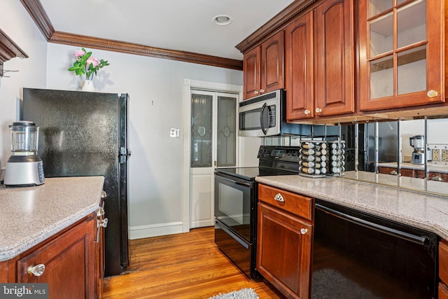 114 Walsh Rd, Lansdowne, PA 19050 - kitchen with black appliances, ornamental molding, light wood-type flooring, and glass insert cabinets