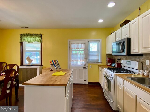 2634 Yorkway, Baltimore, MD 21222 - kitchen featuring white gas range oven, stainless steel microwave, butcher block countertops, dark wood-type flooring, and backsplash