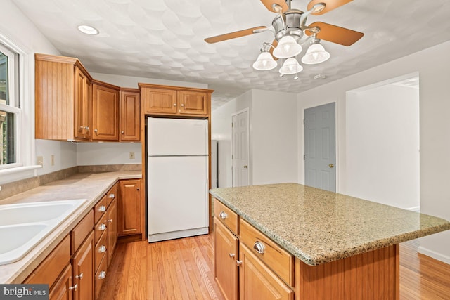 421 Old Stage Rd, Lewisberry, PA 17339 - kitchen featuring freestanding refrigerator, ceiling fan, light wood-style floors, a kitchen island, and brown cabinetry