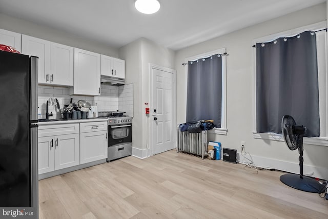 400 E Vernon Rd, Philadelphia, PA 19119 - kitchen with high end range, freestanding refrigerator, white cabinets, under cabinet range hood, and light wood-style floors