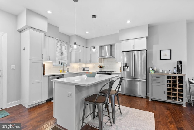 1837 N Palethorp St, Philadelphia, PA 19122 - kitchen with appliances with stainless steel finishes, wall chimney range hood, dark wood-style floors, a breakfast bar area, and light countertops