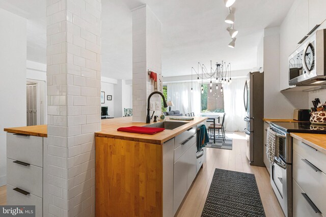 4301 Massachusetts Ave NW Unit A212, Washington, DC 20016 - kitchen featuring wood counters, appliances with stainless steel finishes, modern cabinets, and light wood-type flooring