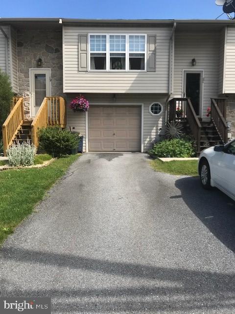 21 E Elm St, Lebanon, PA 17042 - raised ranch featuring a garage, driveway, and stone siding