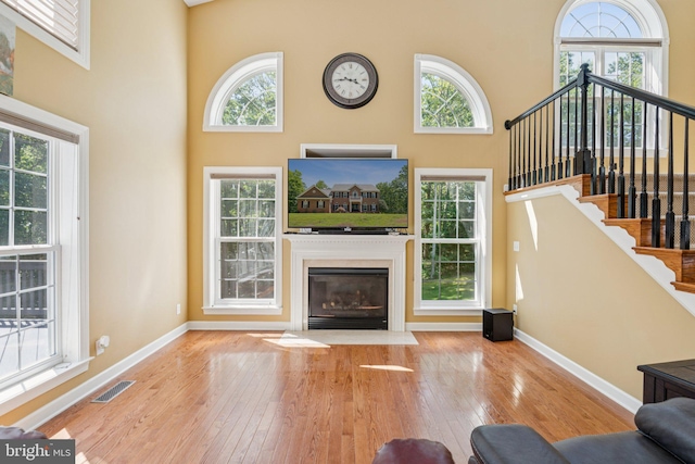 1340 Mountain View Rd, Stafford, VA 22554 - living room featuring hardwood / wood-style flooring, a high ceiling, stairway, and a fireplace with flush hearth