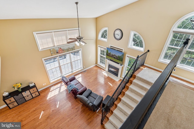 1340 Mountain View Rd, Stafford, VA 22554 - living room with wood finished floors, a high ceiling, a ceiling fan, a fireplace with flush hearth, and stairway