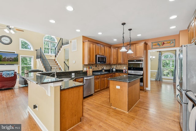 1340 Mountain View Rd, Stafford, VA 22554 - kitchen featuring appliances with stainless steel finishes, ceiling fan, a peninsula, light wood finished floors, and a center island