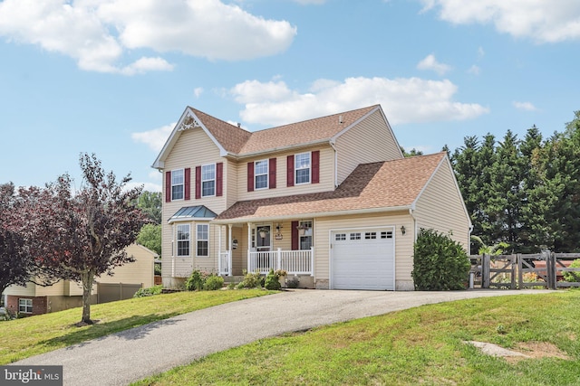 2640 E Colonial Dr, Upper Chichester, PA 19061 - traditional-style house featuring a porch, an attached garage, asphalt driveway, and roof with shingles