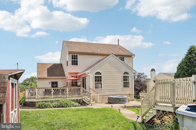 2640 E Colonial Dr, Upper Chichester, PA 19061 - rear view of property with a hot tub, a deck, and a lawn