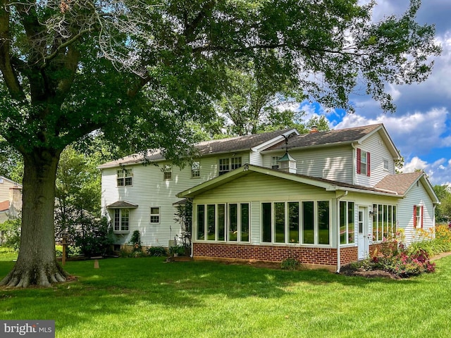 886 Laurel Ln, Harleysville, PA 19438 - rear view of property with a sunroom, brick siding, and a lawn