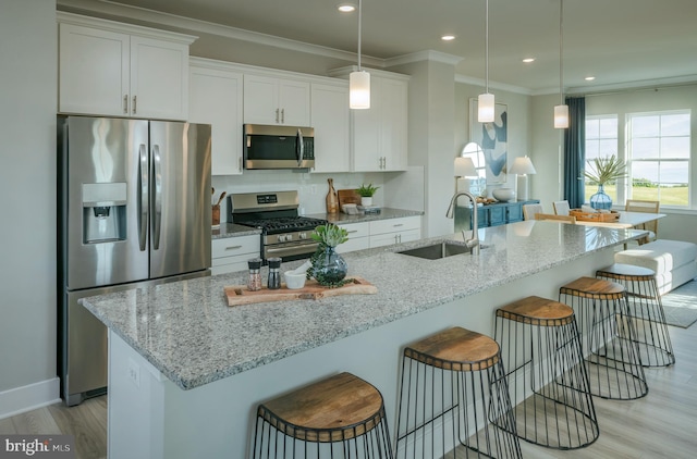 7565 Dundee Rd, Baltimore, MD 21244 - kitchen with appliances with stainless steel finishes, white cabinets, a kitchen bar, light wood-type flooring, and crown molding