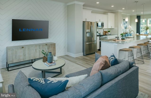 7565 Dundee Rd, Baltimore, MD 21244 - living area featuring light wood-style flooring, ornamental molding, recessed lighting, and an accent wall