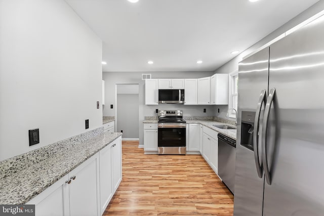 3834 Nancy Ave, Wilmington, DE 19808 - kitchen featuring appliances with stainless steel finishes, light wood-style floors, white cabinets, recessed lighting, and light stone counters