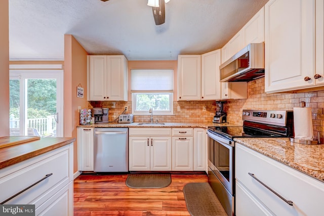 169 Independence Dr, Morrisville, PA 19067 - kitchen featuring appliances with stainless steel finishes, light wood-style floors, plenty of natural light, white cabinetry, and a textured ceiling