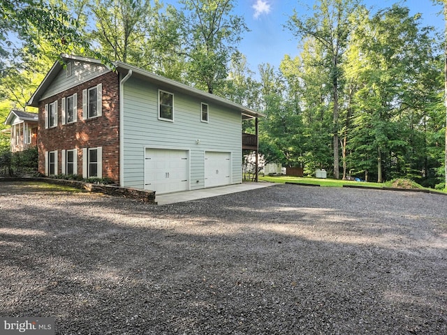 7491 Slagle Ln, Manassas, VA 20111 - view of side of home with gravel driveway, a garage, and brick siding