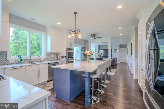 14 Stanley Dr, Monroe Township, NJ 08831 - kitchen featuring appliances with stainless steel finishes, backsplash, light stone countertops, white cabinets, and a kitchen island