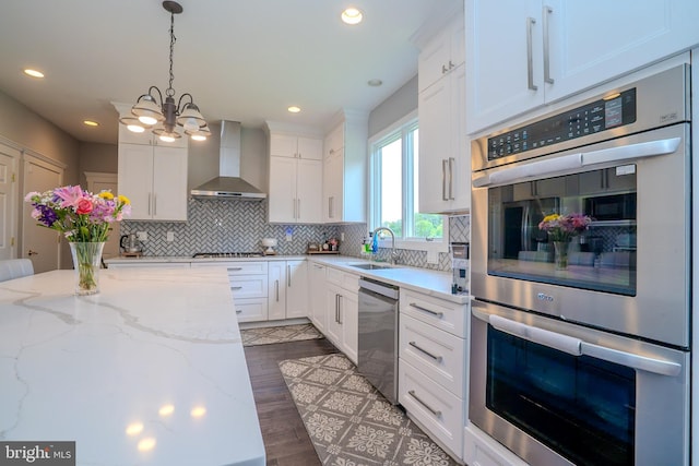 14 Stanley Dr, Monroe Township, NJ 08831 - kitchen featuring wall chimney range hood, appliances with stainless steel finishes, a chandelier, white cabinets, and recessed lighting