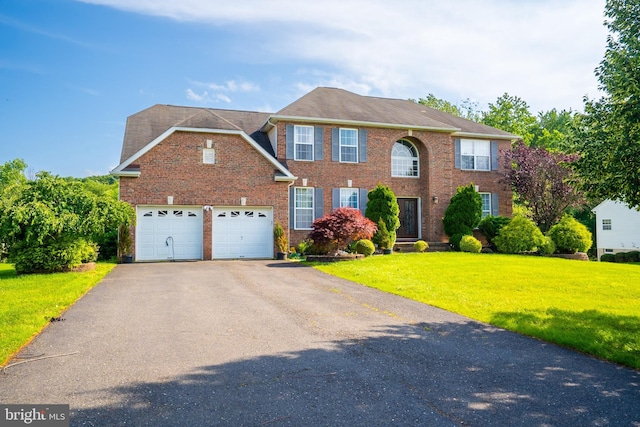 14 Stanley Dr, Monroe Township, NJ 08831 - colonial house with driveway, a front yard, brick siding, and a garage