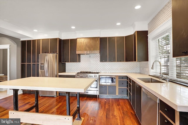 127 Spruce St, Middletown, PA 17057 - kitchen featuring appliances with stainless steel finishes, dark wood-type flooring, dark brown cabinets, arched walkways, and tasteful backsplash