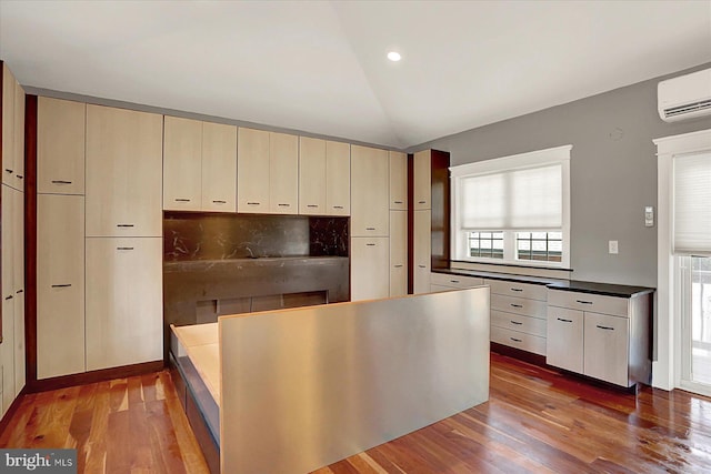 127 Spruce St, Middletown, PA 17057 - kitchen with a wall mounted AC, wood finished floors, vaulted ceiling, dark countertops, and recessed lighting
