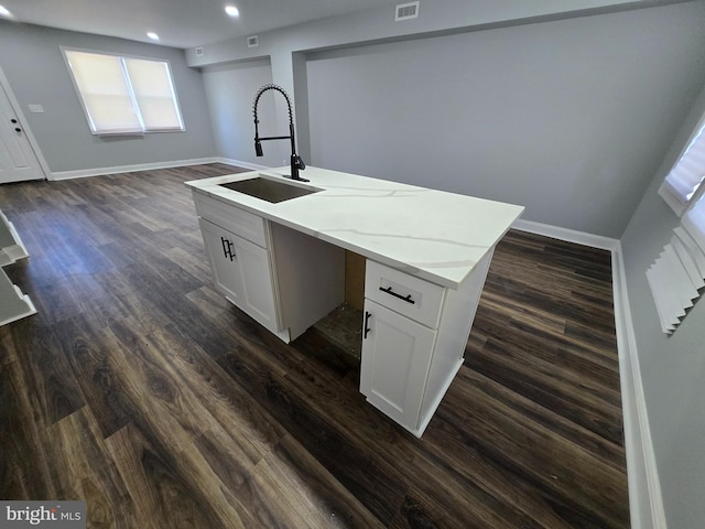 940 E 41st St, Baltimore, MD 21218 - kitchen featuring recessed lighting, a center island with sink, dark wood-style floors, white cabinetry, and light stone countertops