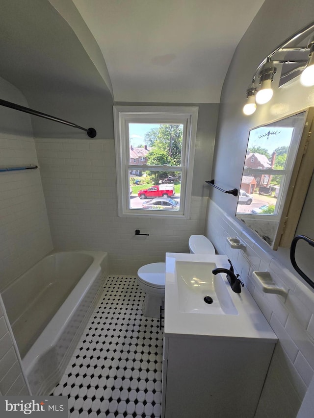 940 E 41st St, Baltimore, MD 21218 - bathroom featuring tile walls, vanity, bathing tub / shower combination, wainscoting, and tile patterned flooring