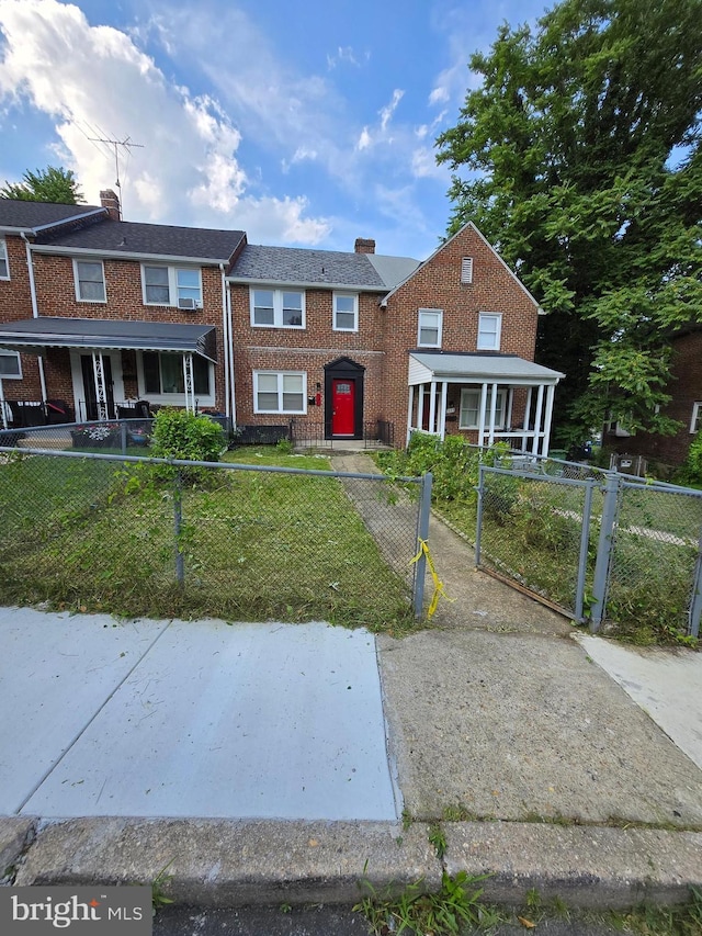 940 E 41st St, Baltimore, MD 21218 - townhome / multi-family property featuring a chimney, a fenced front yard, brick siding, and a gate