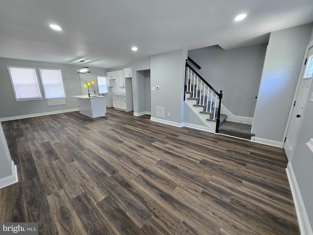 940 E 41st St, Baltimore, MD 21218 - unfurnished living room featuring dark wood finished floors, stairway, and recessed lighting