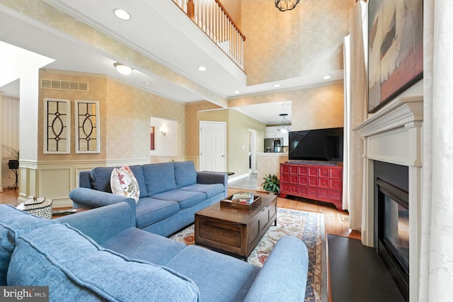 28 White Birch Blvd, Bear, DE 19701 - living room featuring wood finished floors, ornamental molding, a glass covered fireplace, recessed lighting, and a wainscoted wall