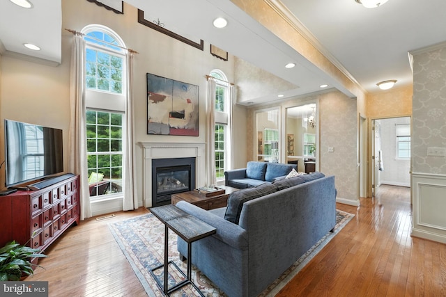 28 White Birch Blvd, Bear, DE 19701 - living room featuring wallpapered walls, light wood-type flooring, ornamental molding, and a glass covered fireplace