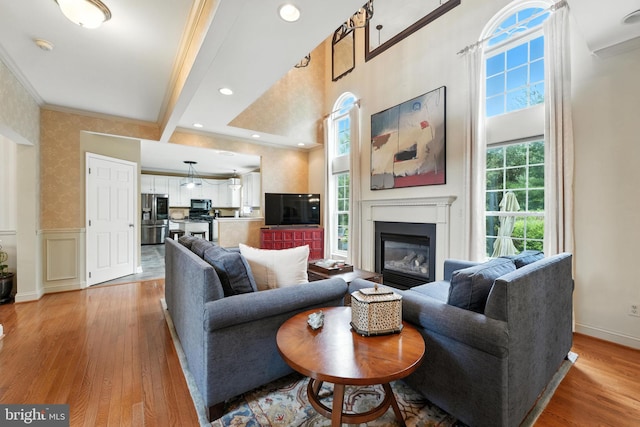 28 White Birch Blvd, Bear, DE 19701 - living room featuring ornamental molding, light wood-type flooring, a wainscoted wall, a glass covered fireplace, and wallpapered walls