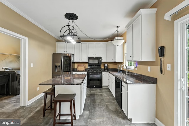 28 White Birch Blvd, Bear, DE 19701 - kitchen with black appliances, washer and dryer, ornamental molding, healthy amount of natural light, and a center island
