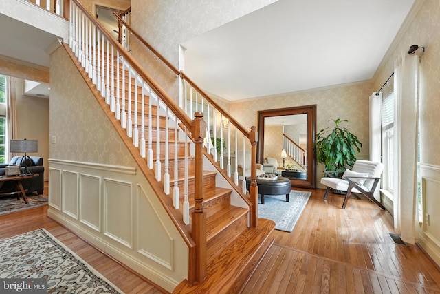 28 White Birch Blvd, Bear, DE 19701 - staircase with wallpapered walls, healthy amount of natural light, hardwood / wood-style flooring, wainscoting, and a decorative wall