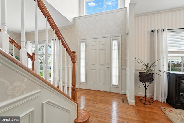 28 White Birch Blvd, Bear, DE 19701 - entrance foyer with wallpapered walls, healthy amount of natural light, light wood-type flooring, stairs, and ornamental molding