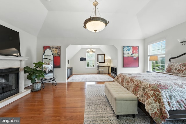 28 White Birch Blvd, Bear, DE 19701 - bedroom with lofted ceiling, wood finished floors, a chandelier, and a fireplace with raised hearth