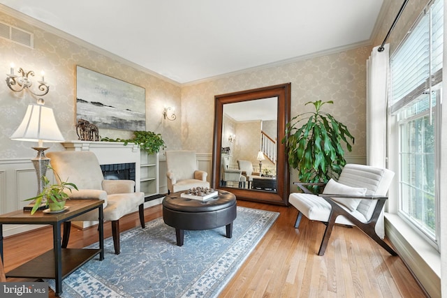 28 White Birch Blvd, Bear, DE 19701 - living area featuring hardwood / wood-style floors, wallpapered walls, a fireplace, crown molding, and wainscoting