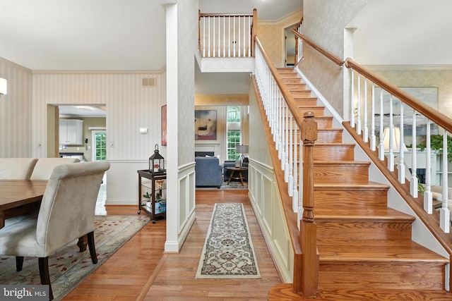28 White Birch Blvd, Bear, DE 19701 - stairs featuring wallpapered walls, a fireplace, wood finished floors, crown molding, and a wainscoted wall