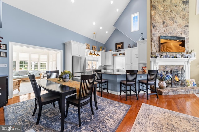 336 Lincoln Rd, Pilesgrove, NJ 08098 - dining area with high vaulted ceiling, a fireplace, wood finished floors, and recessed lighting
